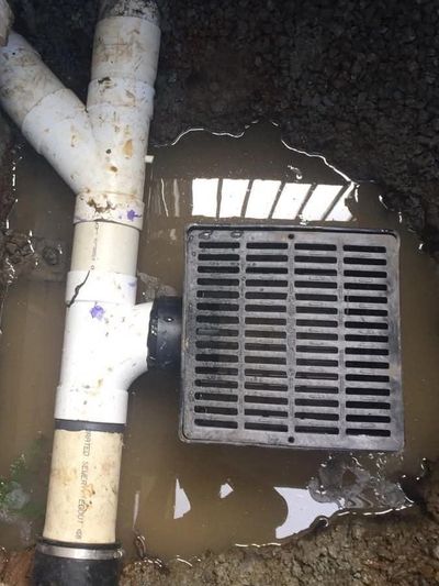 Professional surface drain and catch basin installation by Fairytale Landscaping & Drainage.