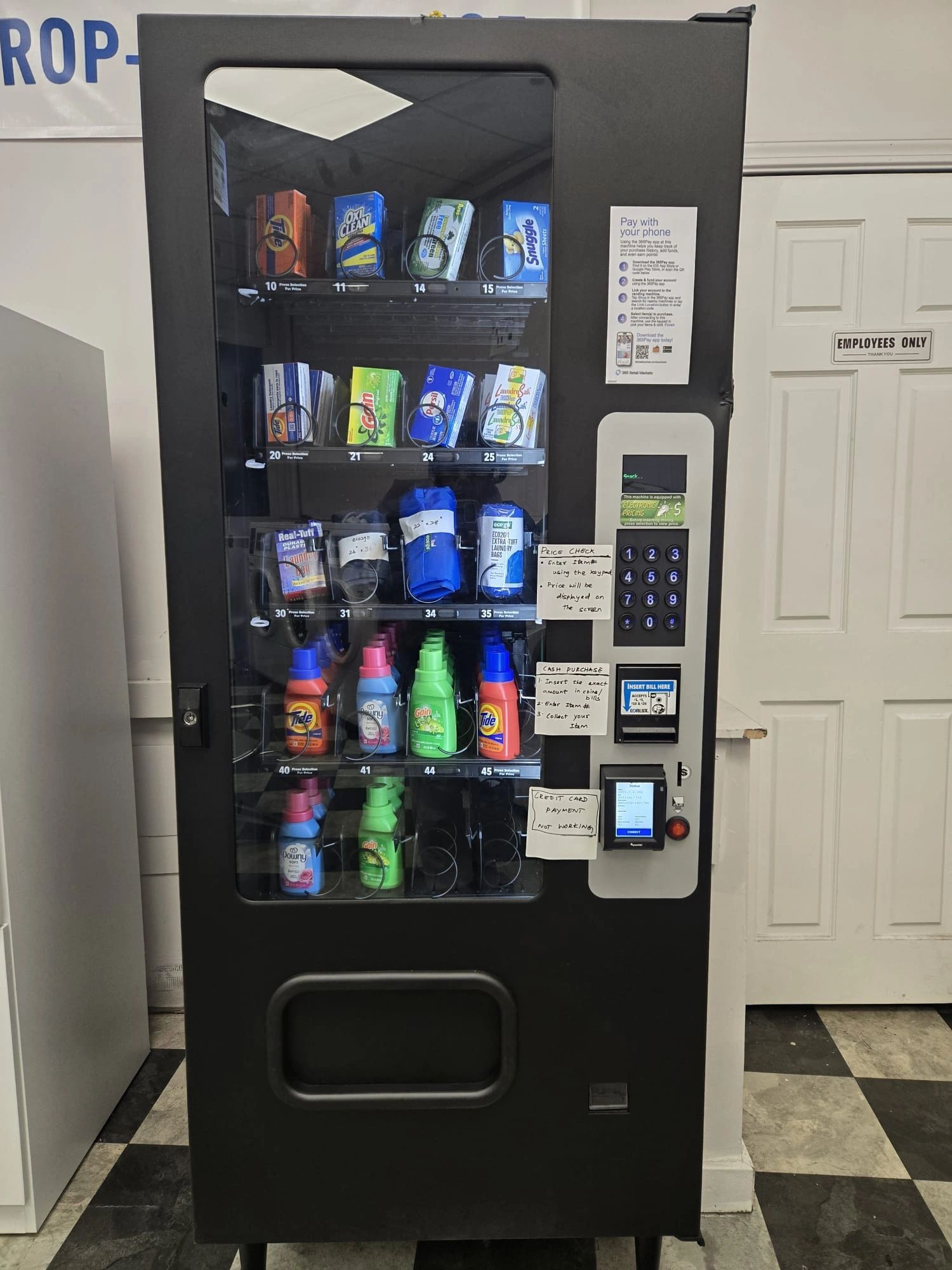 Vending machine selling laundry supplies with instructions and a credit card payment notice.