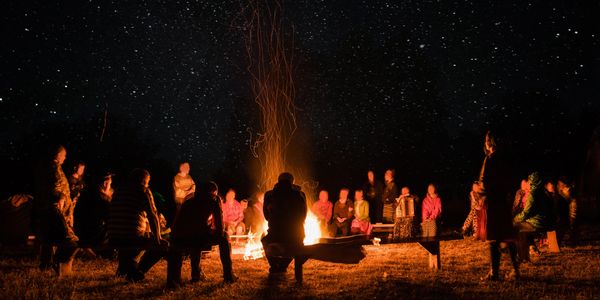 country music lifestyle enthusiasts enjoying an outdoor bonfire while camping under the stars