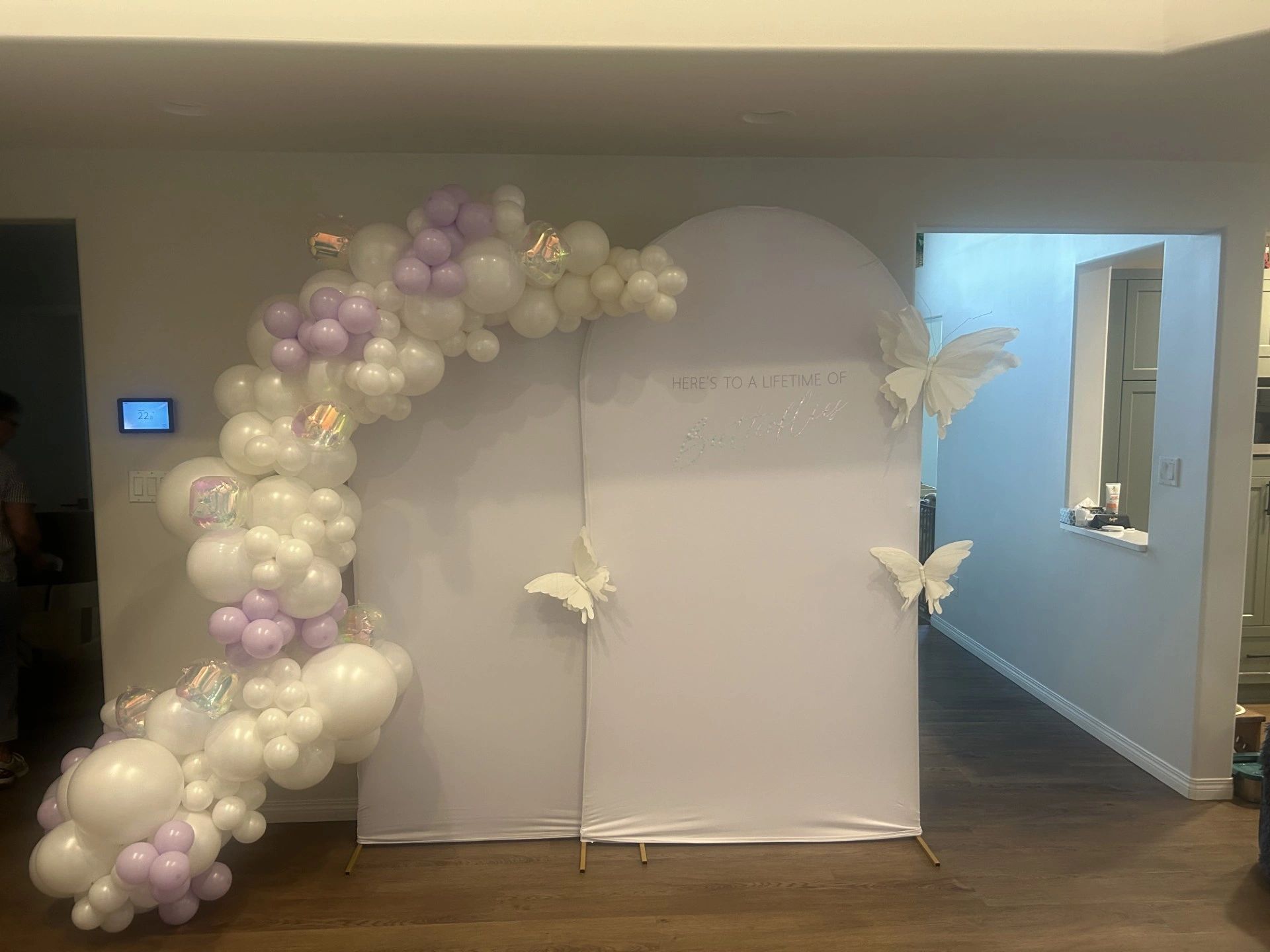 Decorative arch with balloons and butterflies for a celebration.