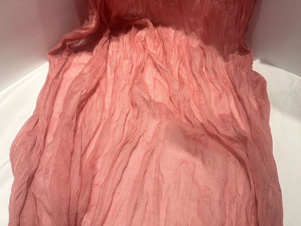 Wrinkled pink fabric spread out.