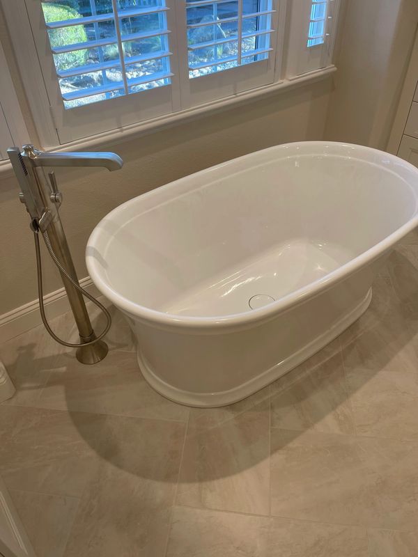 Freestanding Kohler bathtub and Moen tub filler faucet 