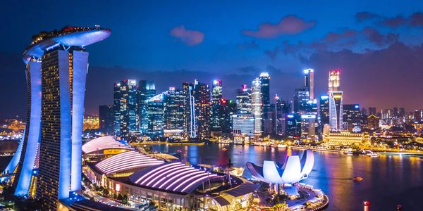 Night view of Singapore skyline with Marina Bay Sands and city lights.