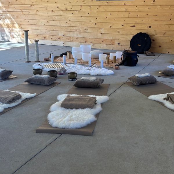 A serene meditation space with mats, cushions, and soft blankets arranged in a circle.