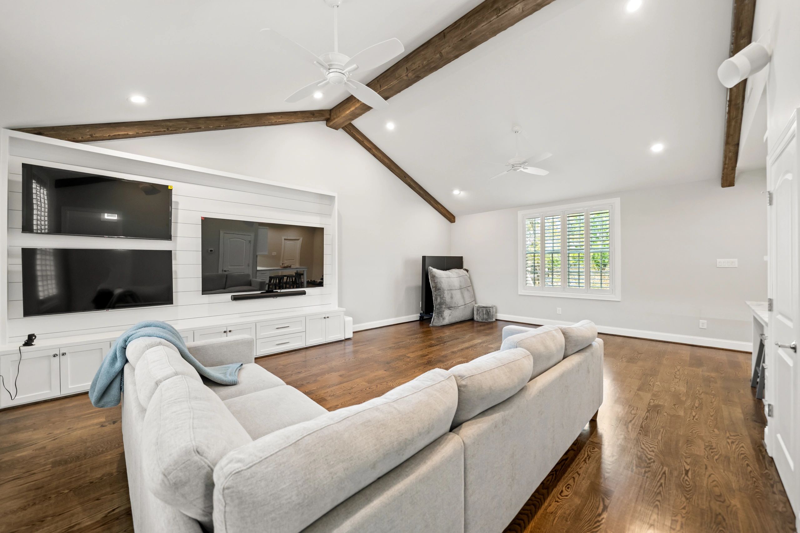 Spacious living room with vaulted ceiling and wooden beams.  Home By Olivo Remodeling LLC Houston