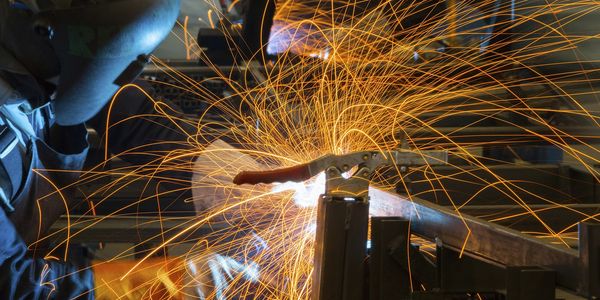 A welder creating bright sparks while working on metal.