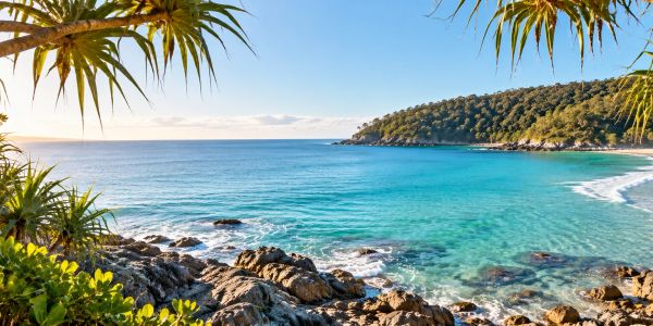 Clear blue ocean with rocky shore and greenery.