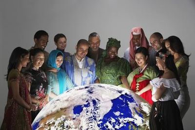 Diverse group of people gathered around a large globe.