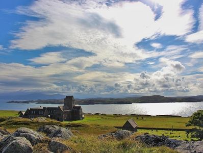 An abbey on grass, with view of the sea and broad sky