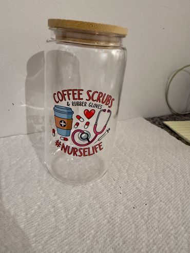 Clear jar with wooden lid featuring nurse-themed coffee design.