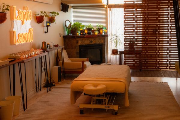 Cozy massage room with warm lighting and plants.