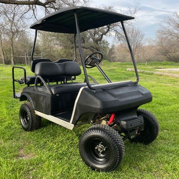 A 2003 Club Car DS with with black Rhino lined paint, a 6in A arm light, and a rear flip seat.