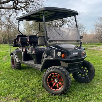 A 2017 EZGO Express L6 with red wheels and red and black seats.