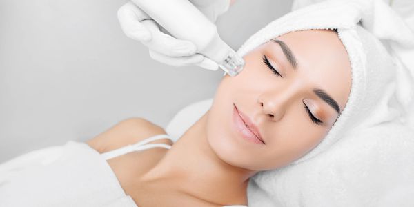 Woman receiving a facial skin treatment with a handheld device.
