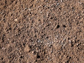 Close-up of dry, brown soil with small rocks and pebbles.