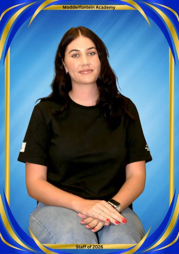 Portrait of a woman with dark hair sitting against a blue background.
