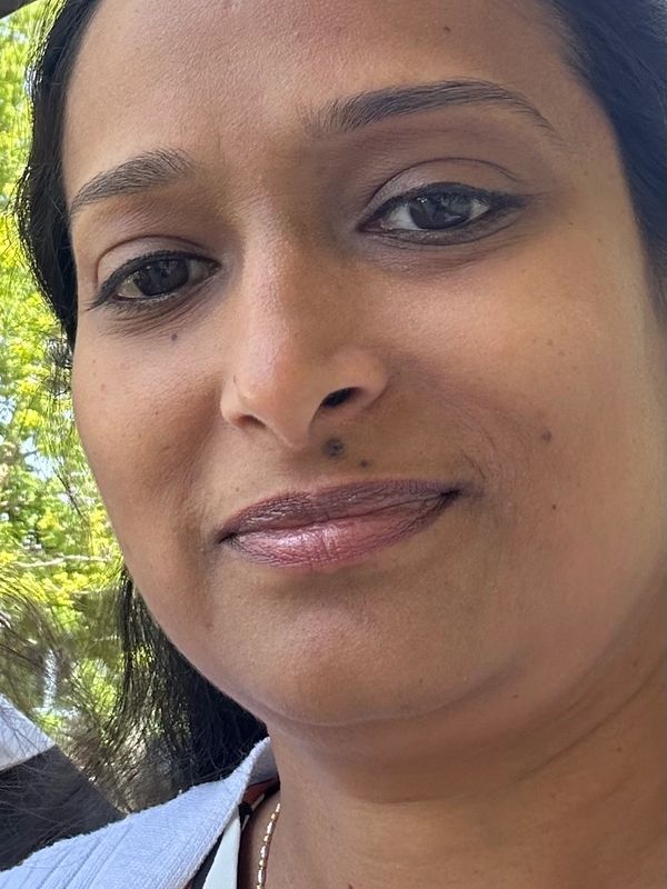 Close-up of a woman smiling outdoors.