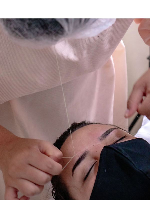 Professional eyebrow threading treatment performed with precision.