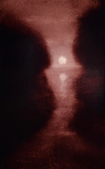 Silhouetted faces facing each other with a glowing orb in the center.