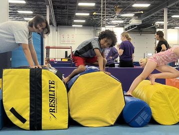 Children climbing on gym foam blocks.