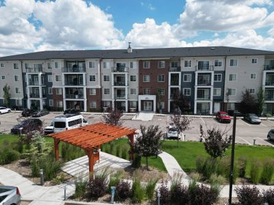 Apartment building with outdoor garden and parking area.