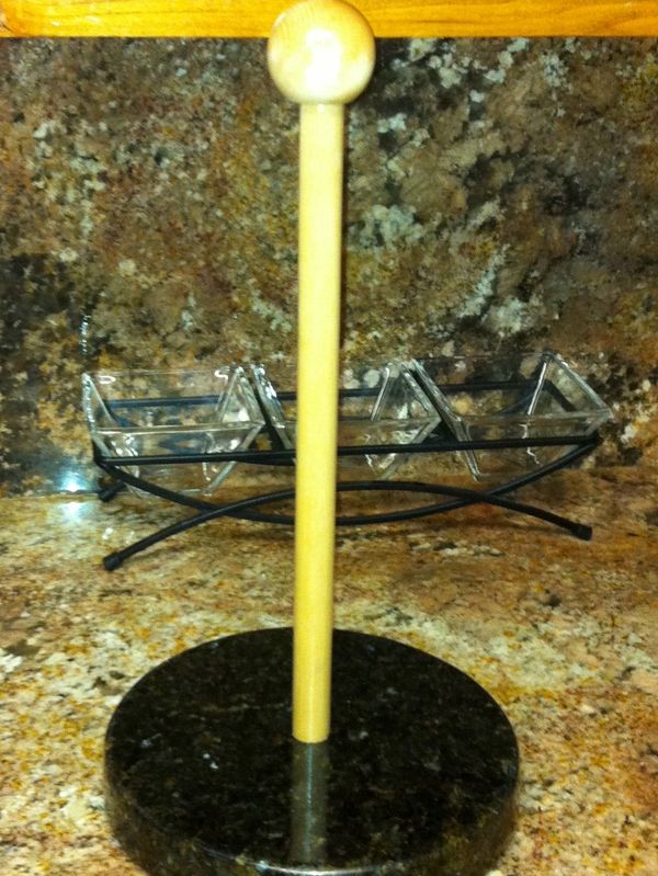 Wooden paper towel holder on granite counter.