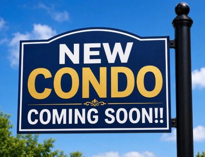 Sign announcing a new condo coming soon against a blue sky.