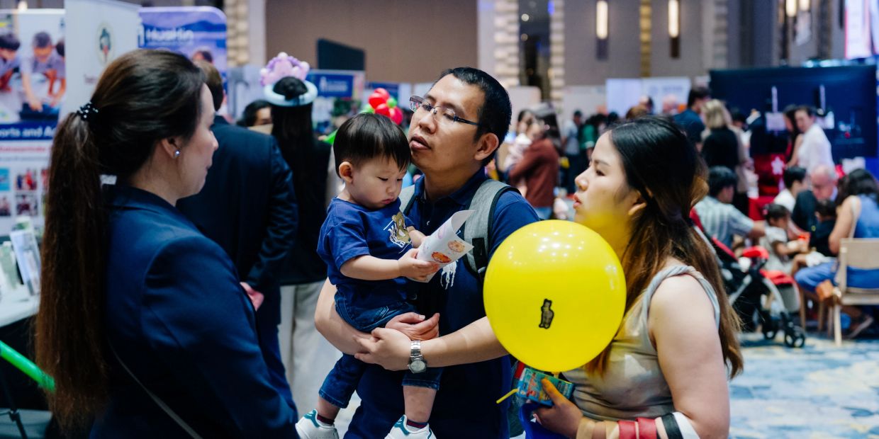 A family with a child at a busy indoor event.