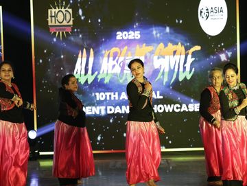 Group of women performing a traditional dance at a cultural showcase event.