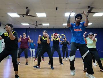 Group dance class in a studio with energetic movements.