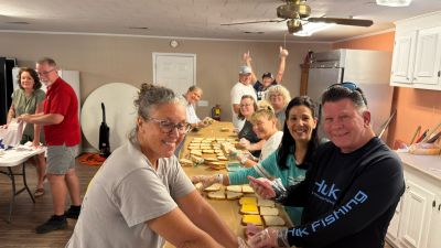 Group assembling sandwiches in a kitchen.