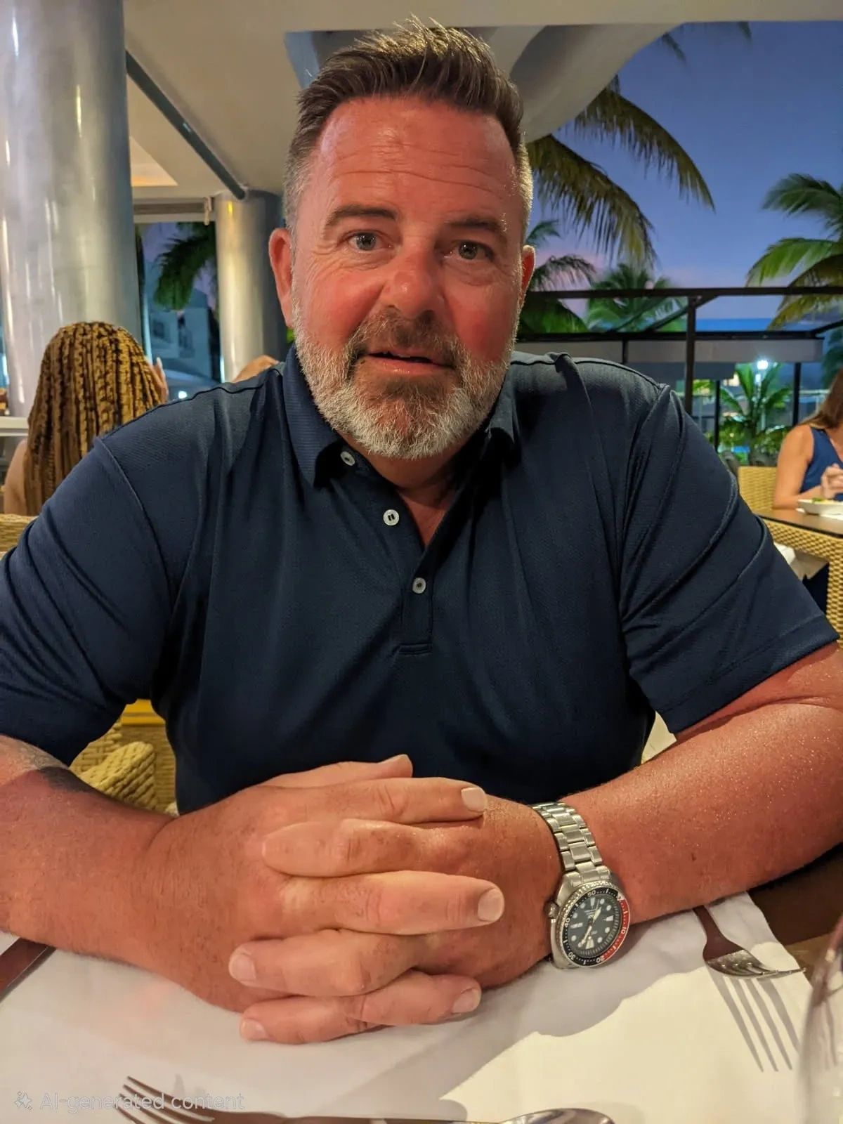 Middle-aged man sitting at a table with a watch.