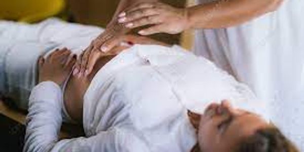 man laying down with woman demonstrating reiki 