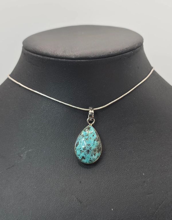 Teardrop turquoise pendant on a thin silver chain.