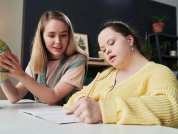 Two girls studying together with a globe.