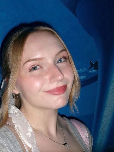 Smiling young woman with light hair and blue eyes.