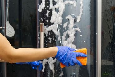 Hand cleaning glass with squeegee.