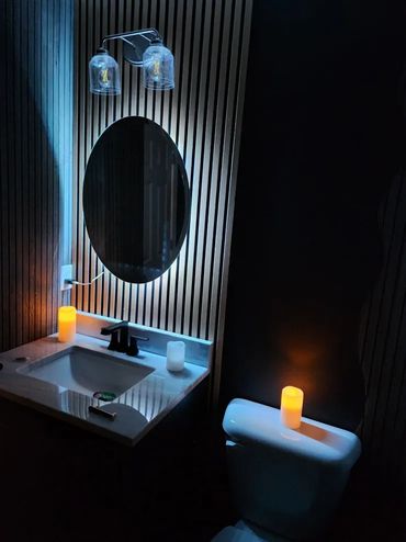 Backlit circular mirror in bathroom.