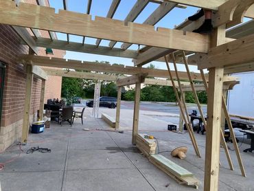 Wooden pergola over outdoor walkway.