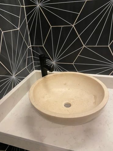 Close-up of beige vessel sink.
