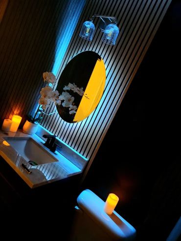 Dark bathroom with round mirror.
