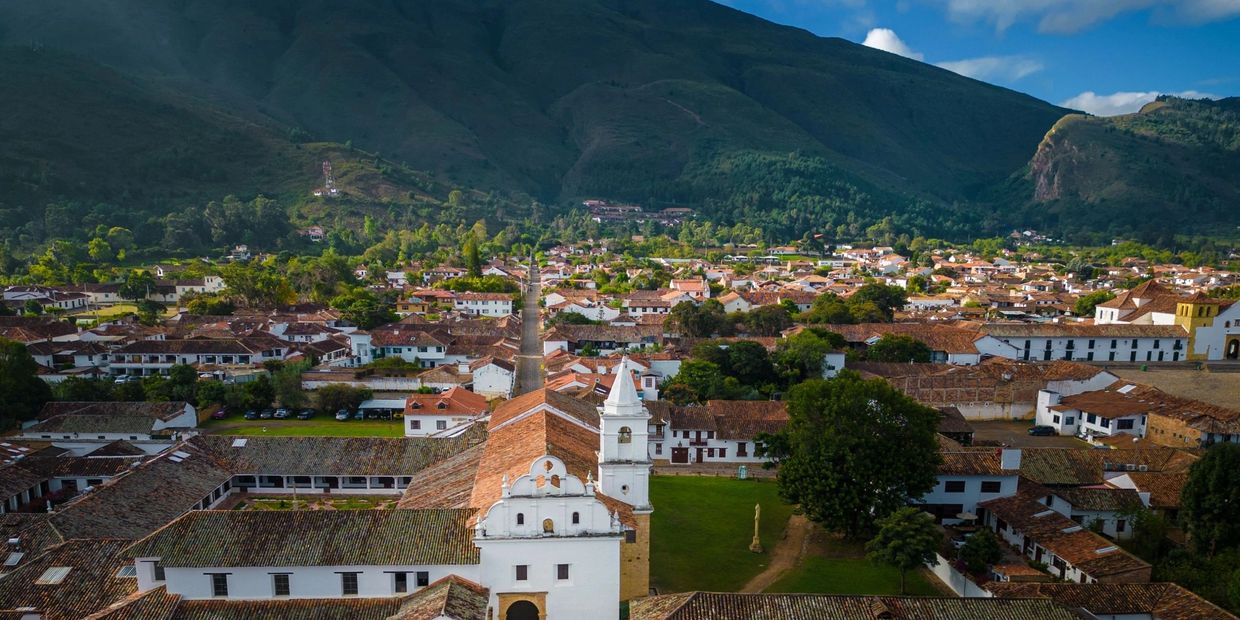 Aerial view of a historic town with tiled roofs and a central church tower.