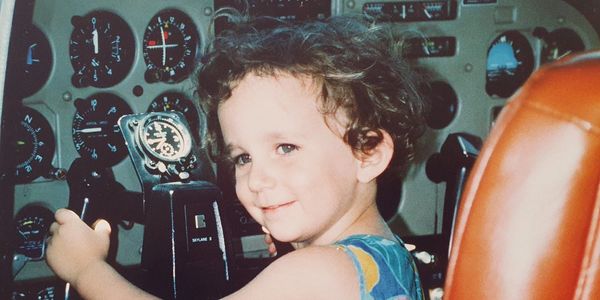 Un jeune enfant souriant dans un cockpit d'avion.