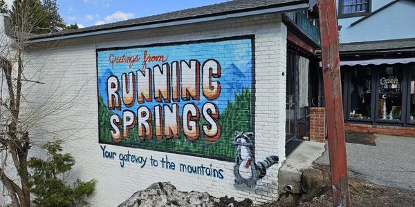 alt="Greetings from Running Springs mural on a brick building in Running Springs, California"