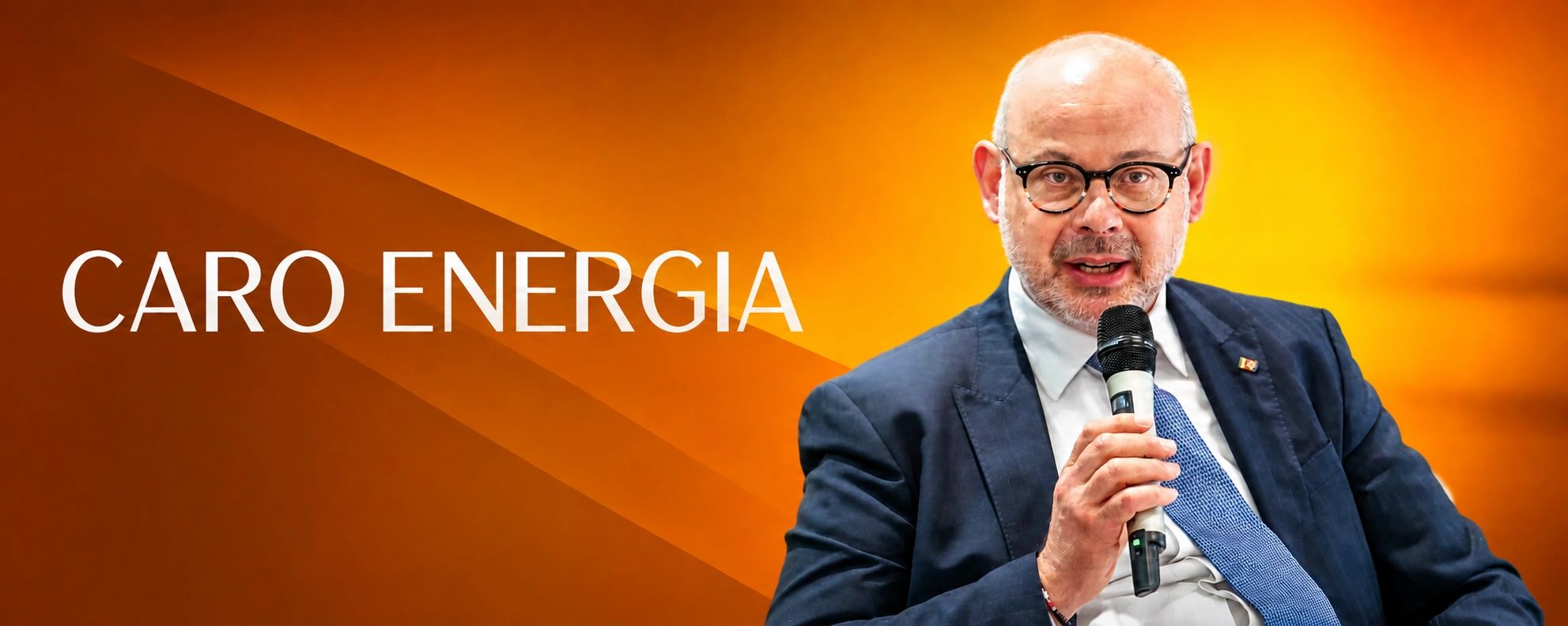 Uomo che parla di caro energia con sfondo arancione.