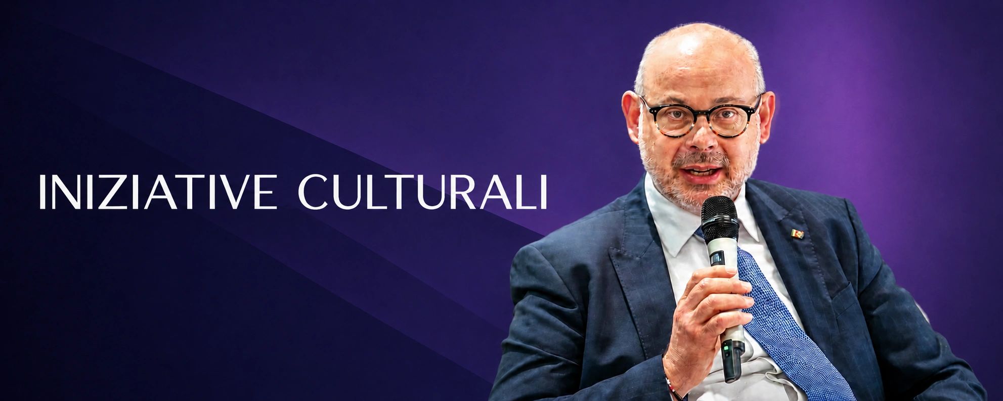Uomo con microfono parla di iniziative culturali.