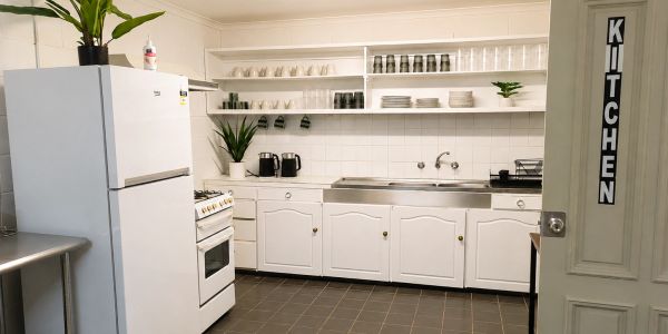 Clean white kitchen with appliances and open shelves.