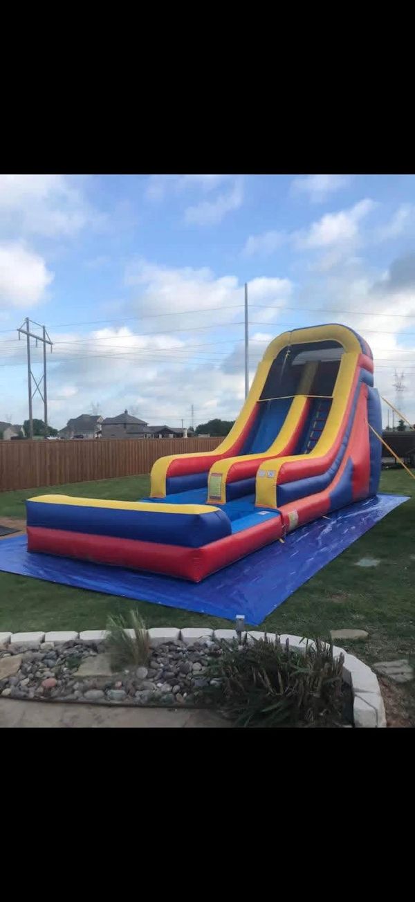 Colorful inflatable water slide set up in a backyard.