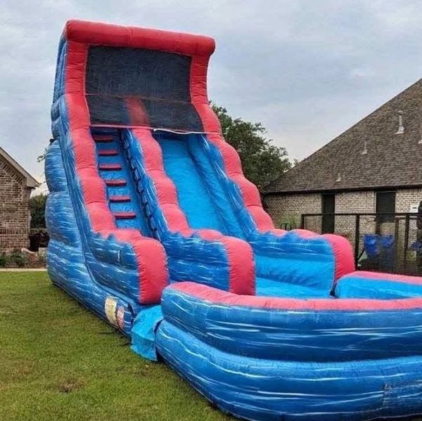 Blue and red inflatable water slide in a backyard.