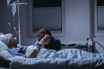 Nurse at bedside with dying pt.